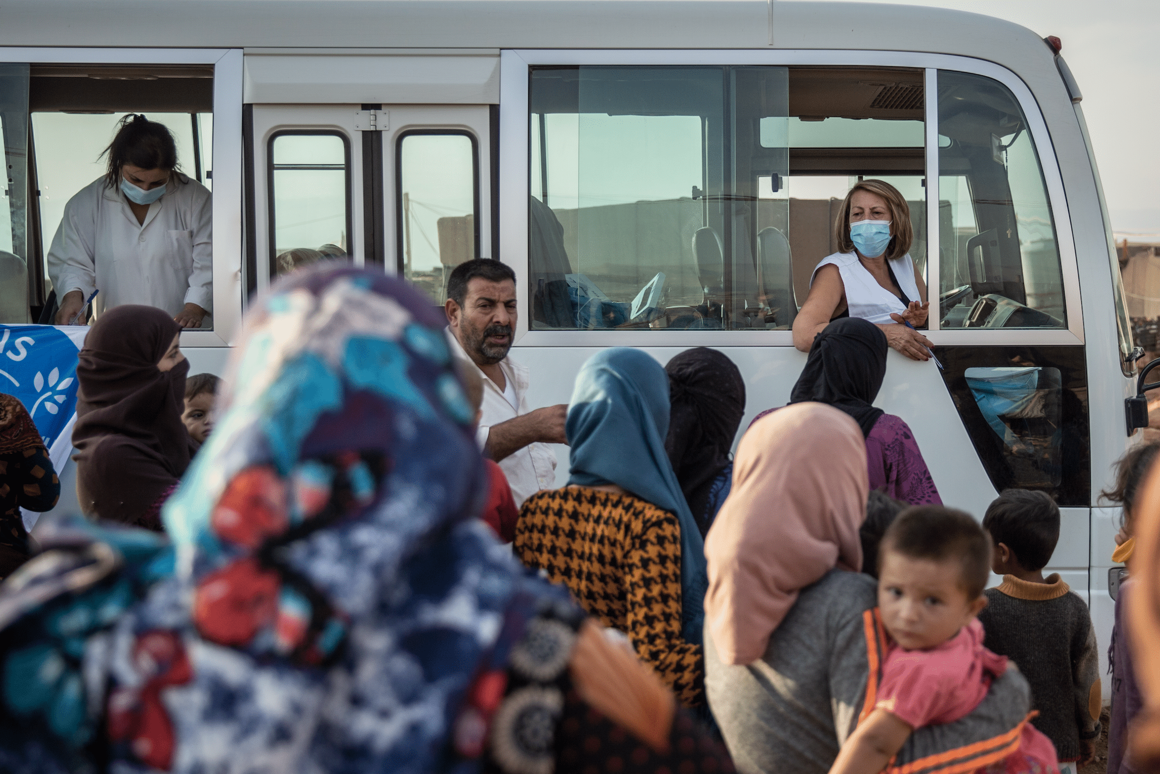 Des personnes réfugiées syriennes font la queue devant une clinique mobile Médecins du Monde